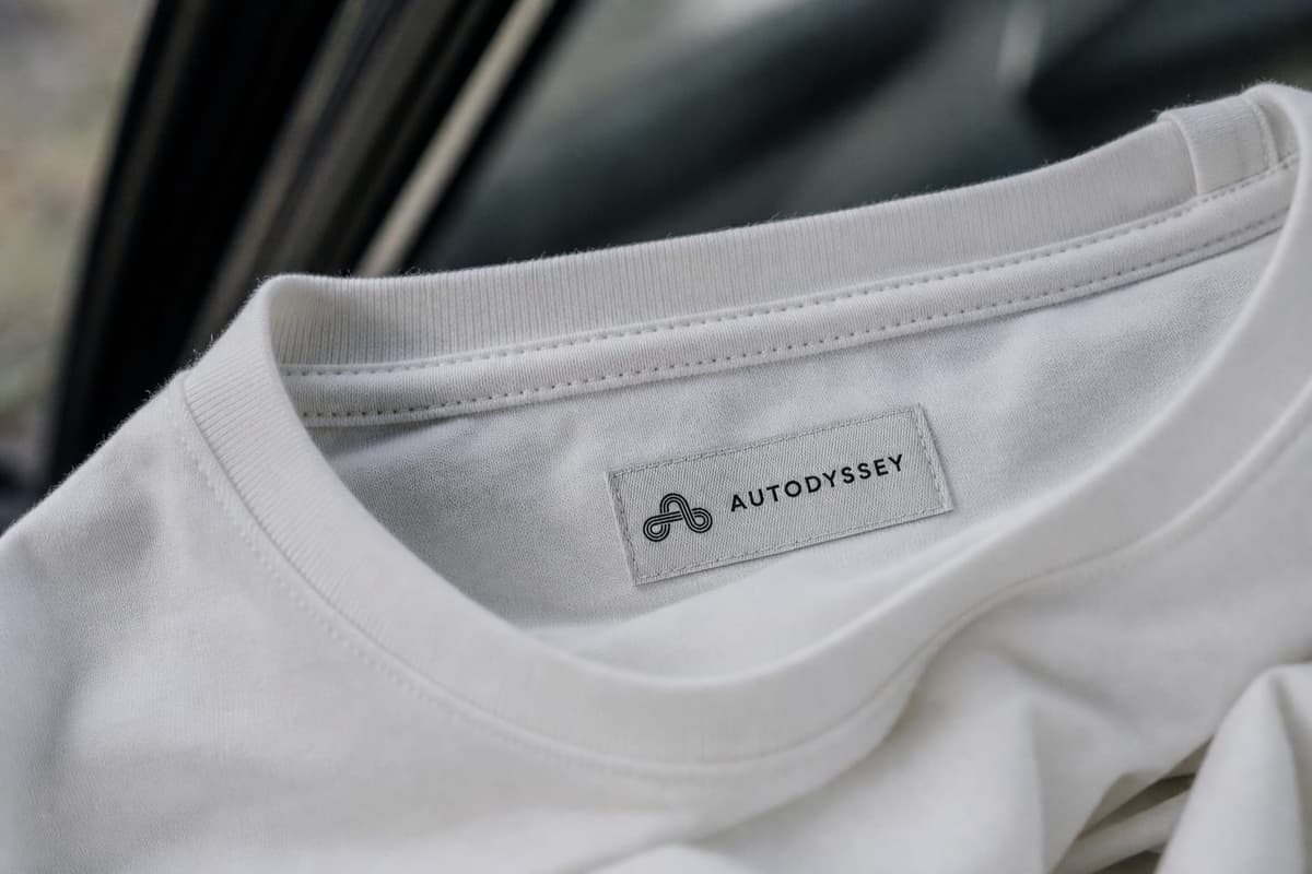 The woven AUTODYSSEY label inside the white tee collar