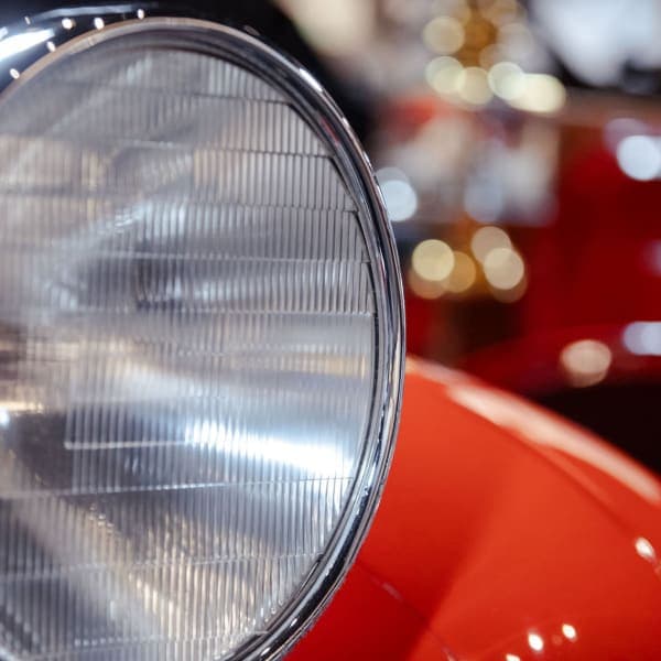 Ribbed-glass headlamp on red coachwork